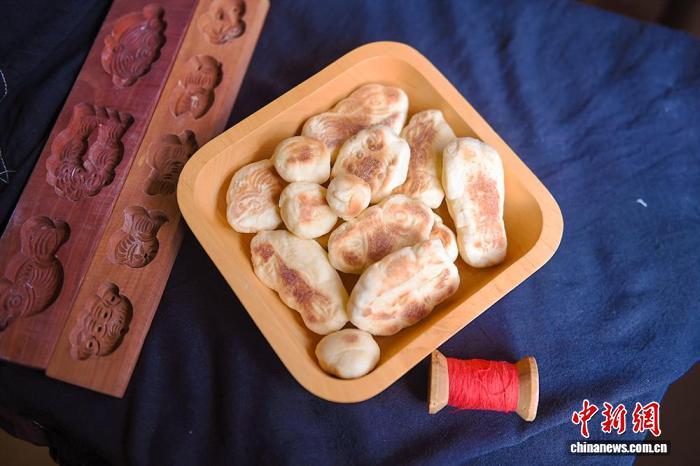 趙金蓉さんが作った巧果。山東省の膠東地区では、旧暦の7月7日に巧果を赤い糸でつなぐ風習があり、それには牛飼いの牛郎と機織りの少女・織女を赤い糸で結びつけるという願いが込められている(撮影・王嬌妮)。